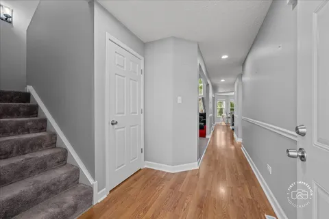 a view of a hallway with wooden floor and entryway