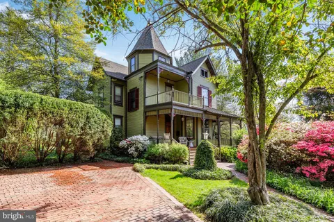 a front view of a house with a yard and fountain in middle