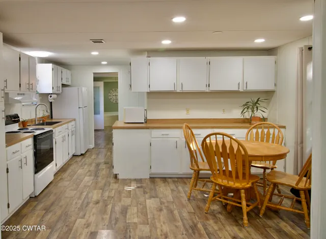 a kitchen with stainless steel appliances granite countertop a stove a sink and white cabinets