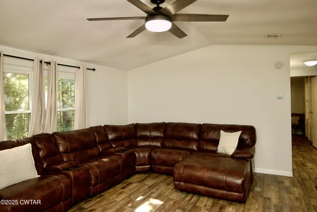 a living room with stainless steel appliances furniture and a window