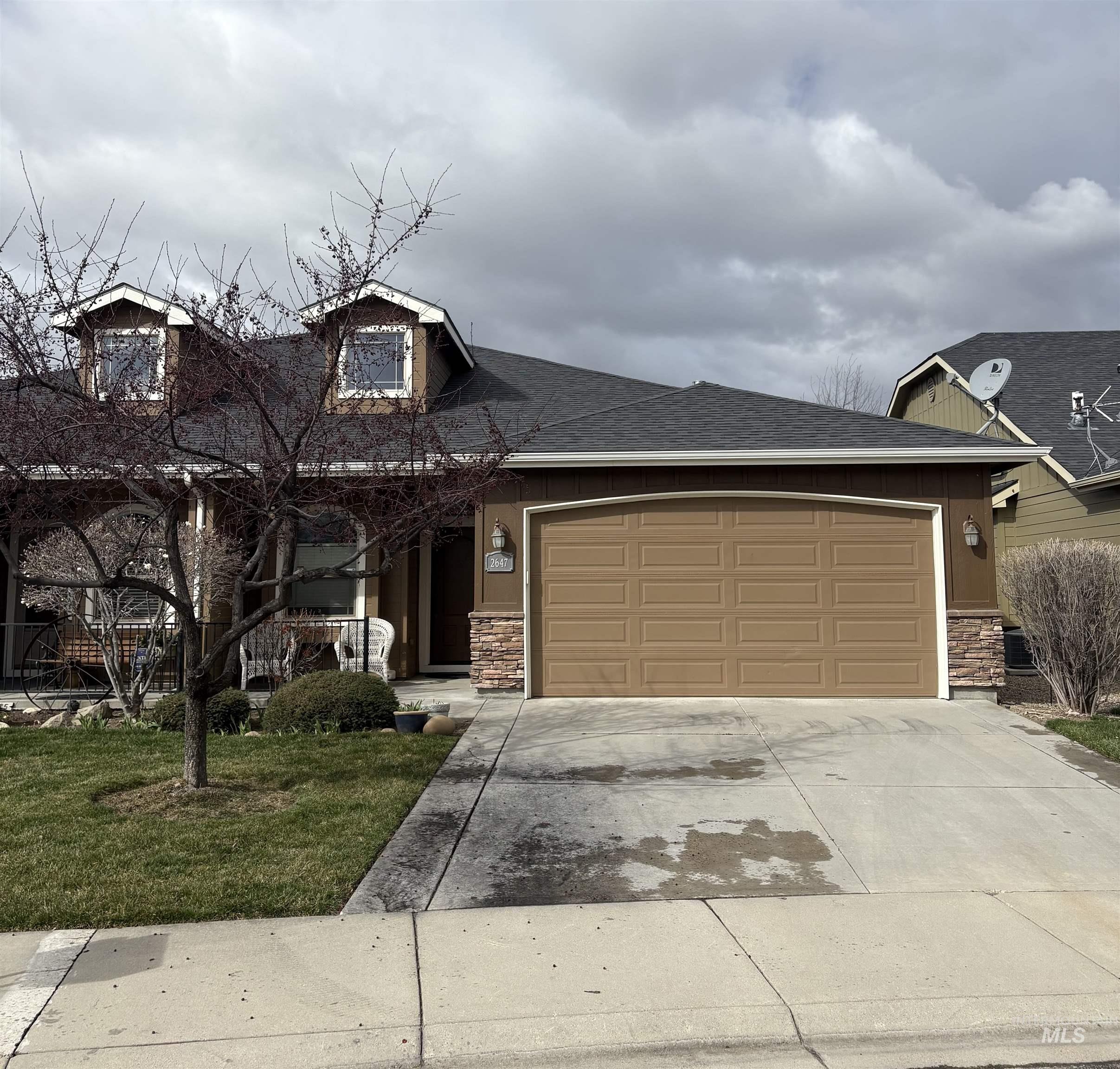 2647 South Legal Avenue Meridian, ID 83642 - Photo 1 of 3 View of front of property with stone siding, driveway, a garage, roof with shingles, and a front lawn