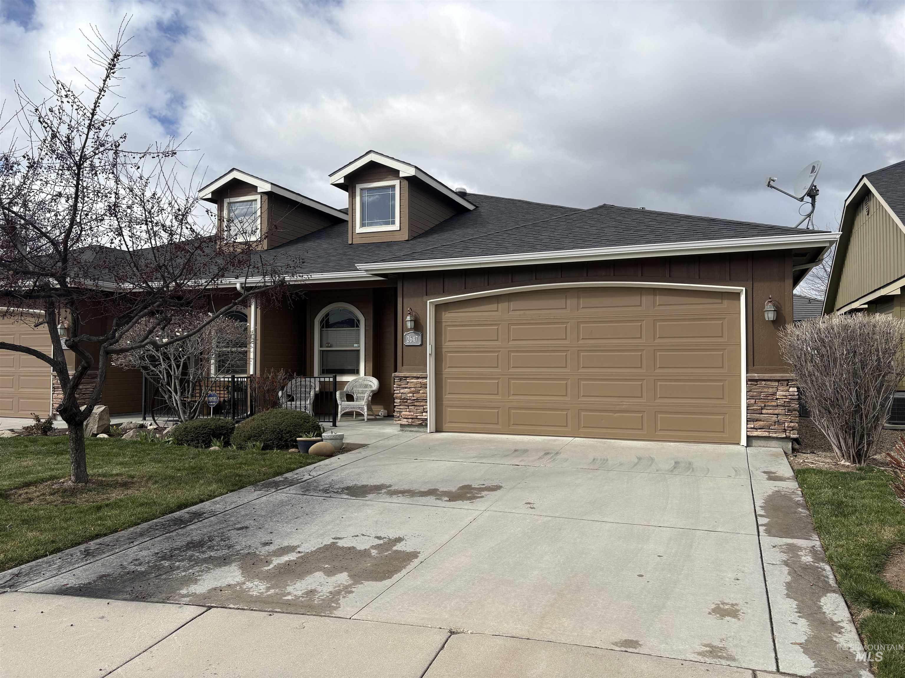 2647 South Legal Avenue Meridian, ID 83642 - Photo 2 of 3 View of front of property featuring stone siding, a shingled roof, driveway, a garage, and covered porch