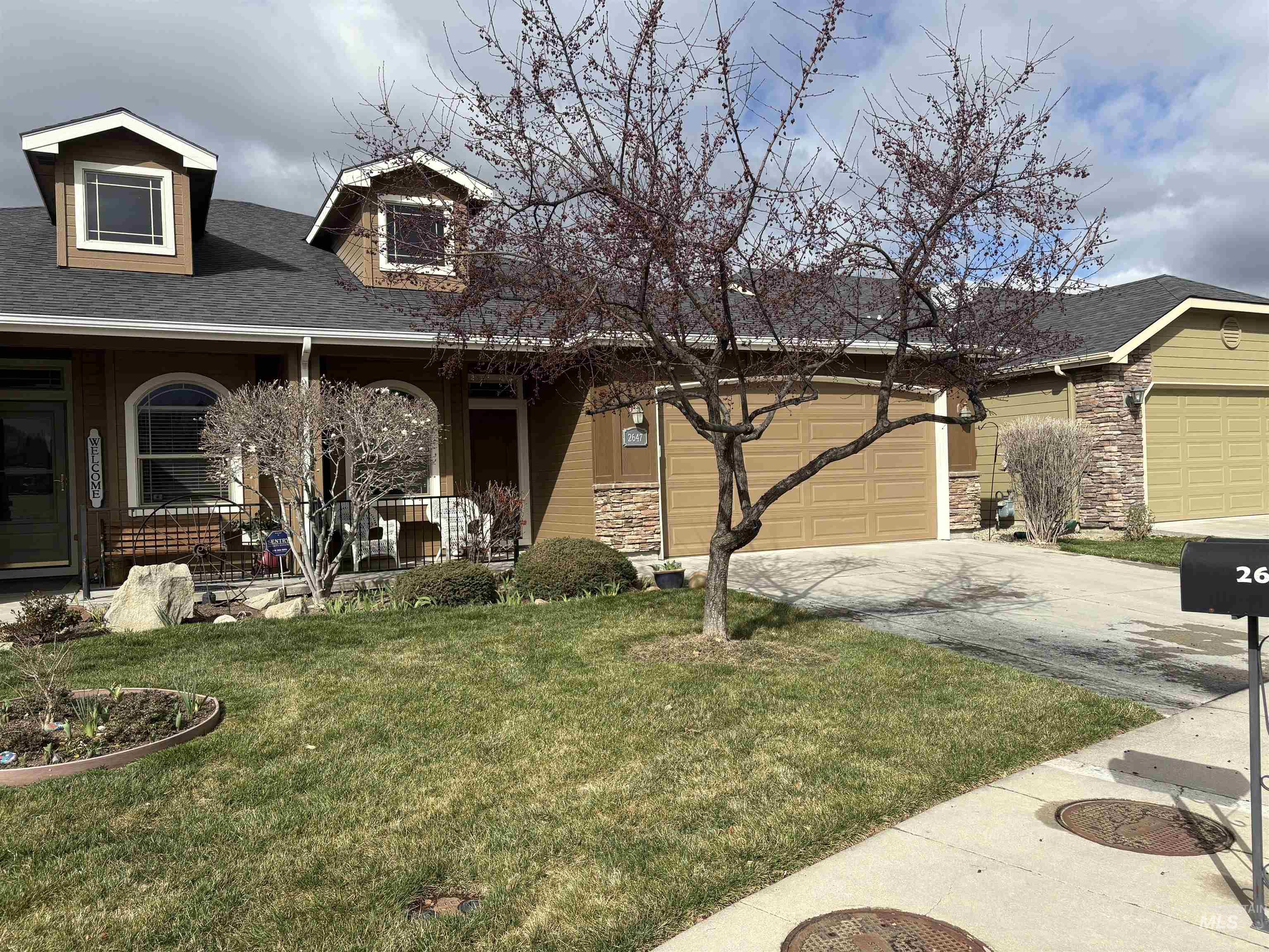 2647 South Legal Avenue Meridian, ID 83642 - Photo 3 of 3 View of front of home featuring roof with shingles, stone siding, concrete driveway, and a front yard