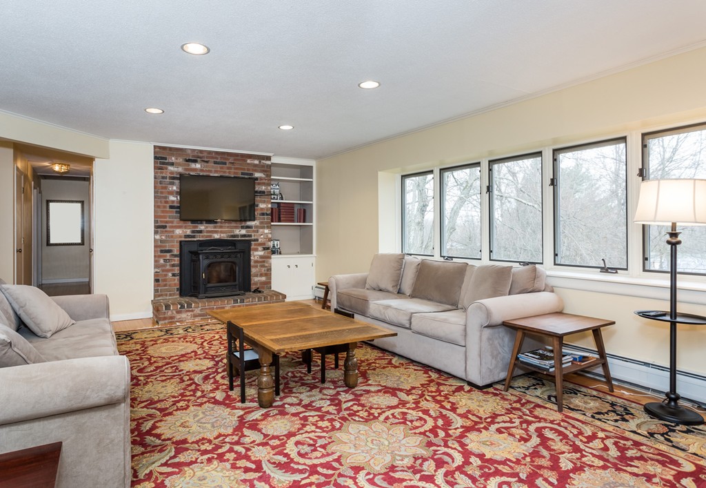 1174 Bay Road Amherst, MA 01002 - Photo 9 of 30 a living room with furniture a rug a fireplace and a flat screen tv