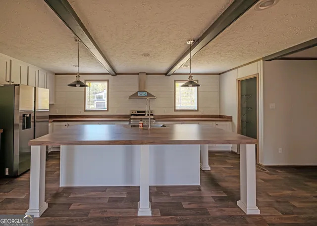 a kitchen with kitchen island a sink appliances and cabinets