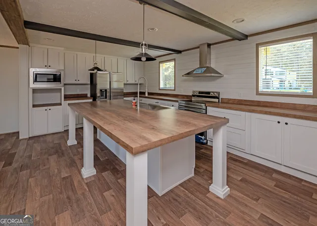 a kitchen with stainless steel appliances granite countertop a sink a stove and a refrigerator
