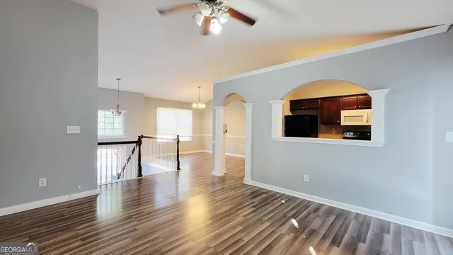 a view of empty room with wooden floor