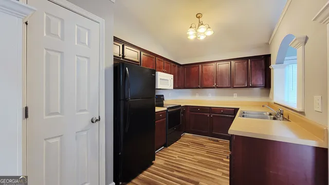 a kitchen with stainless steel appliances granite countertop a refrigerator a sink dishwasher and a stove