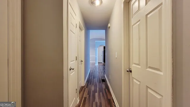 a view of a hallway with wooden floor and staircase