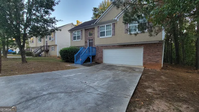a view of a house with a yard and tree