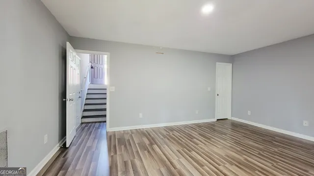 a view of room with stairs and wooden floor