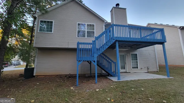 a view of a house with a yard and wooden deck