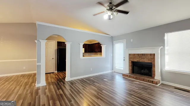 a view of empty room with wooden floor and fireplace