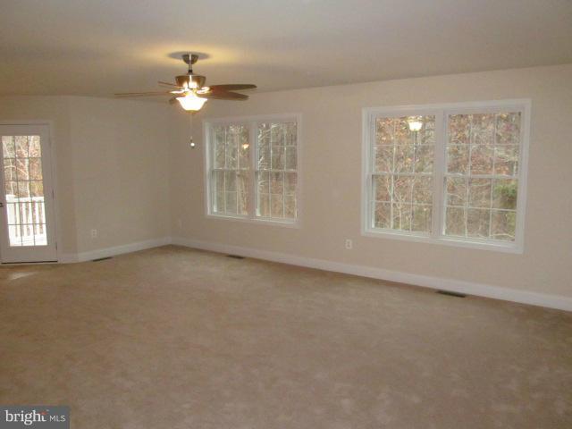 Woodward Lane Rixeyville, VA 22737 - Photo 5 of 19 an empty room with a chandelier fan and windows