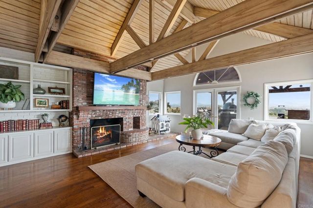 a living room with furniture a flat screen tv and a floor to ceiling window