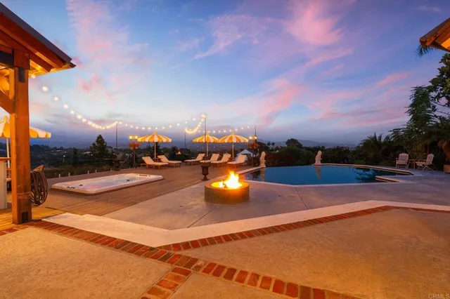 a front view of a house with a yard and mountain view in back