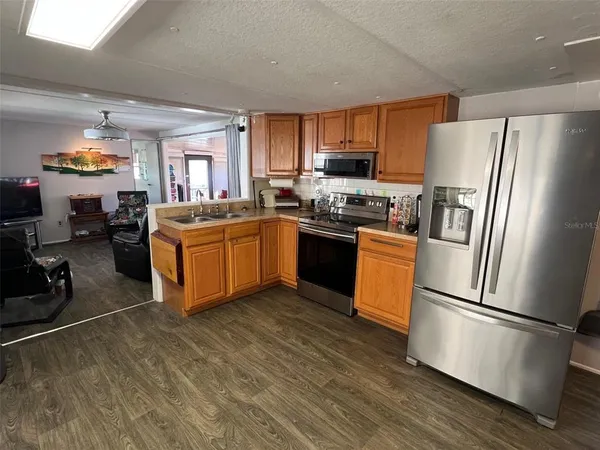 a kitchen with stainless steel appliances granite countertop a refrigerator a stove a sink dishwasher and a refrigerator