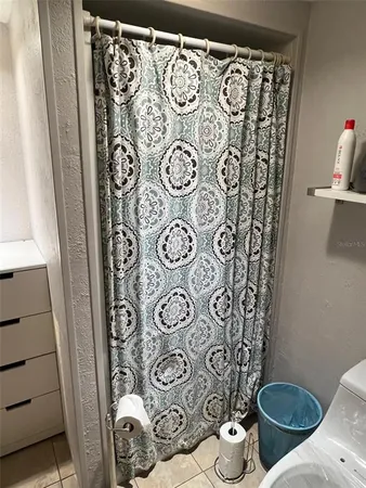 a bathroom with a toilet and a shower curtain