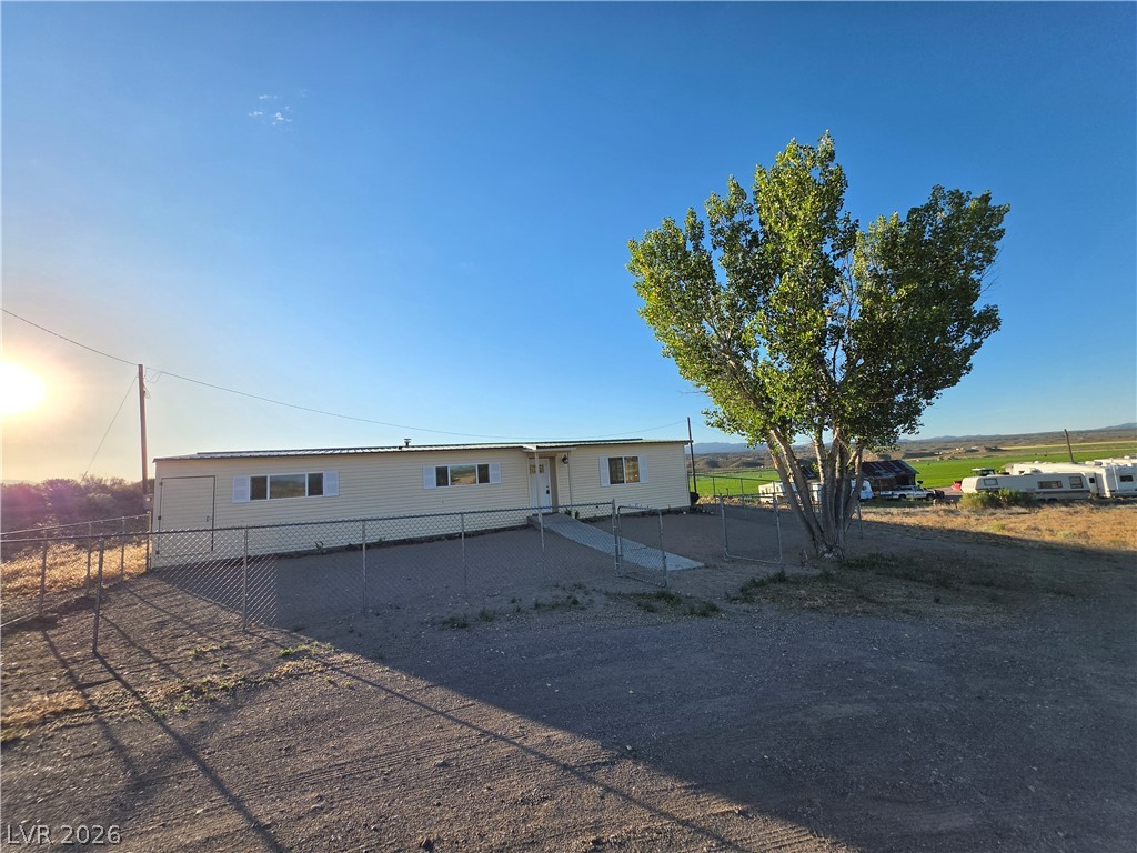 2930 Frehner Ranch Road Pioche, NV 89043 - Photo 3 of 32 A pleasant home with a chain-link fence and a large, verdant tree offers country living.