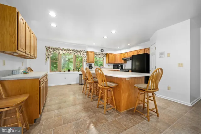 a spacious bedroom with a bed a couch and a flat tv screen on the dresser