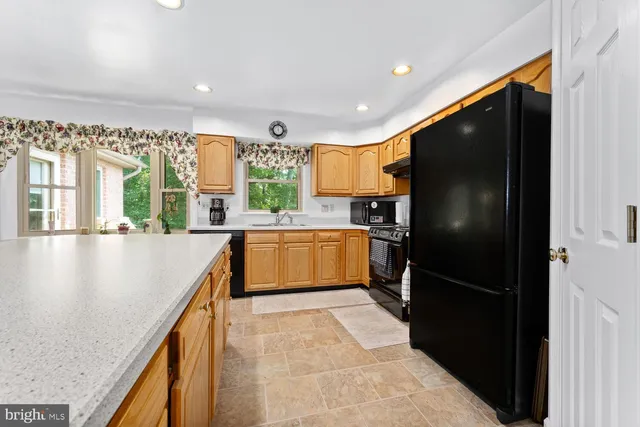 a kitchen with stainless steel appliances granite countertop a stove a sink a refrigerator and a cabinets