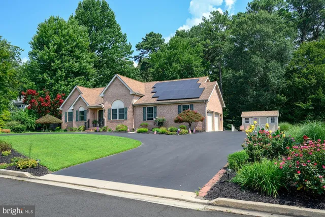 a front view of a house with a yard and potted plants
