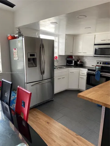 a kitchen with stainless steel appliances kitchen island a refrigerator sink and stove