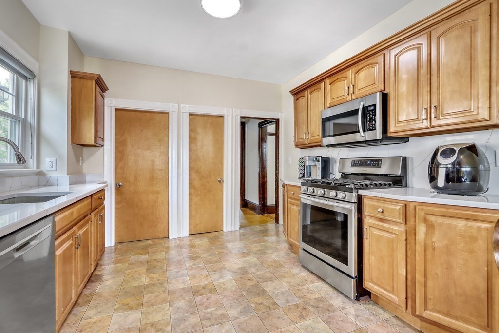 24 Baker Road Everett, MA 02149 - Photo 11 of 26 a kitchen with stainless steel appliances granite countertop a stove a sink and a refrigerator
