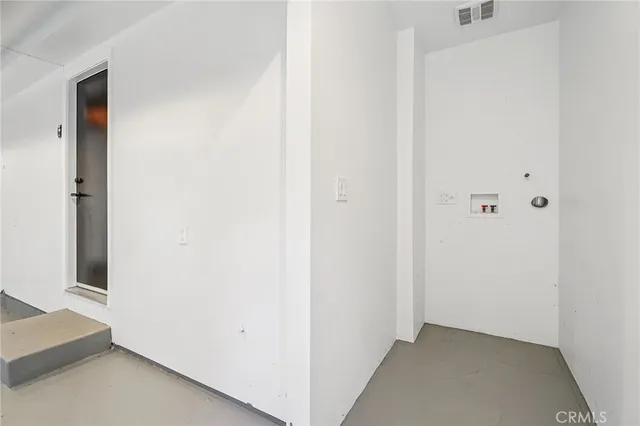 a view of an empty room with furniture and a window