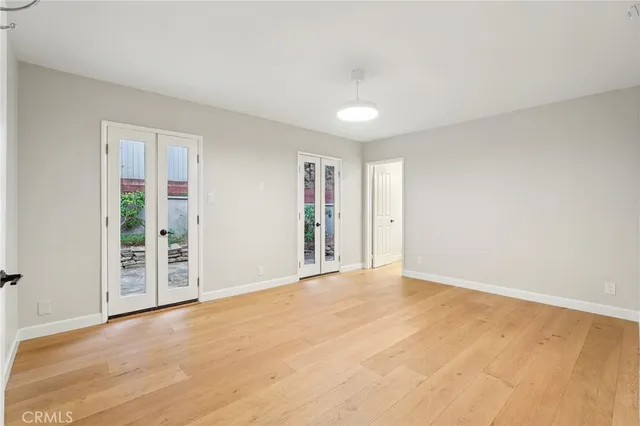a view of a big room with wooden floor and windows