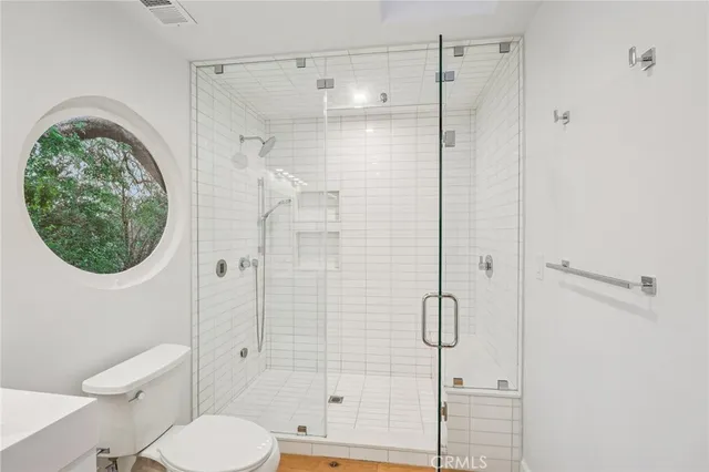 a bathroom with a toilet a sink and mirror