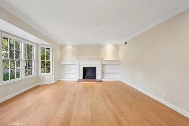 a view of an empty room with a fireplace and a window