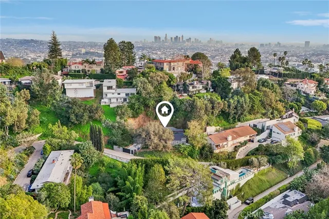 a view of a house with a tree and wooden fence