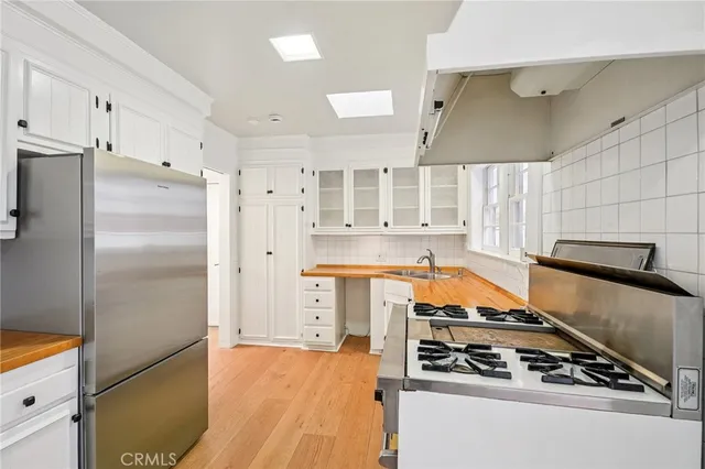 a kitchen with stainless steel appliances a stove a refrigerator and cabinets