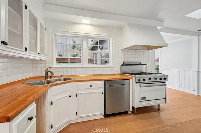 a kitchen with granite countertop a sink stainless steel appliances and cabinets