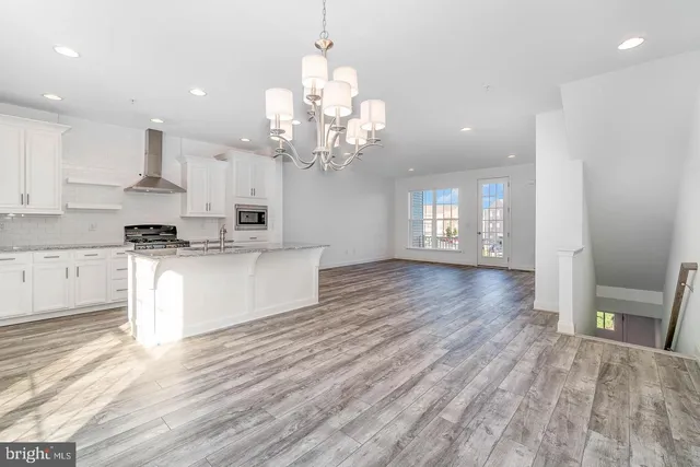a large kitchen with cabinets wooden floor and stainless steel appliances