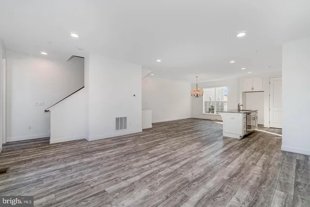 a view of a kitchen with white cabinets and wooden floor