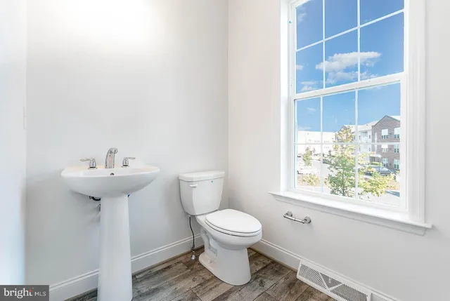 a bathroom with a sink toilet and a window