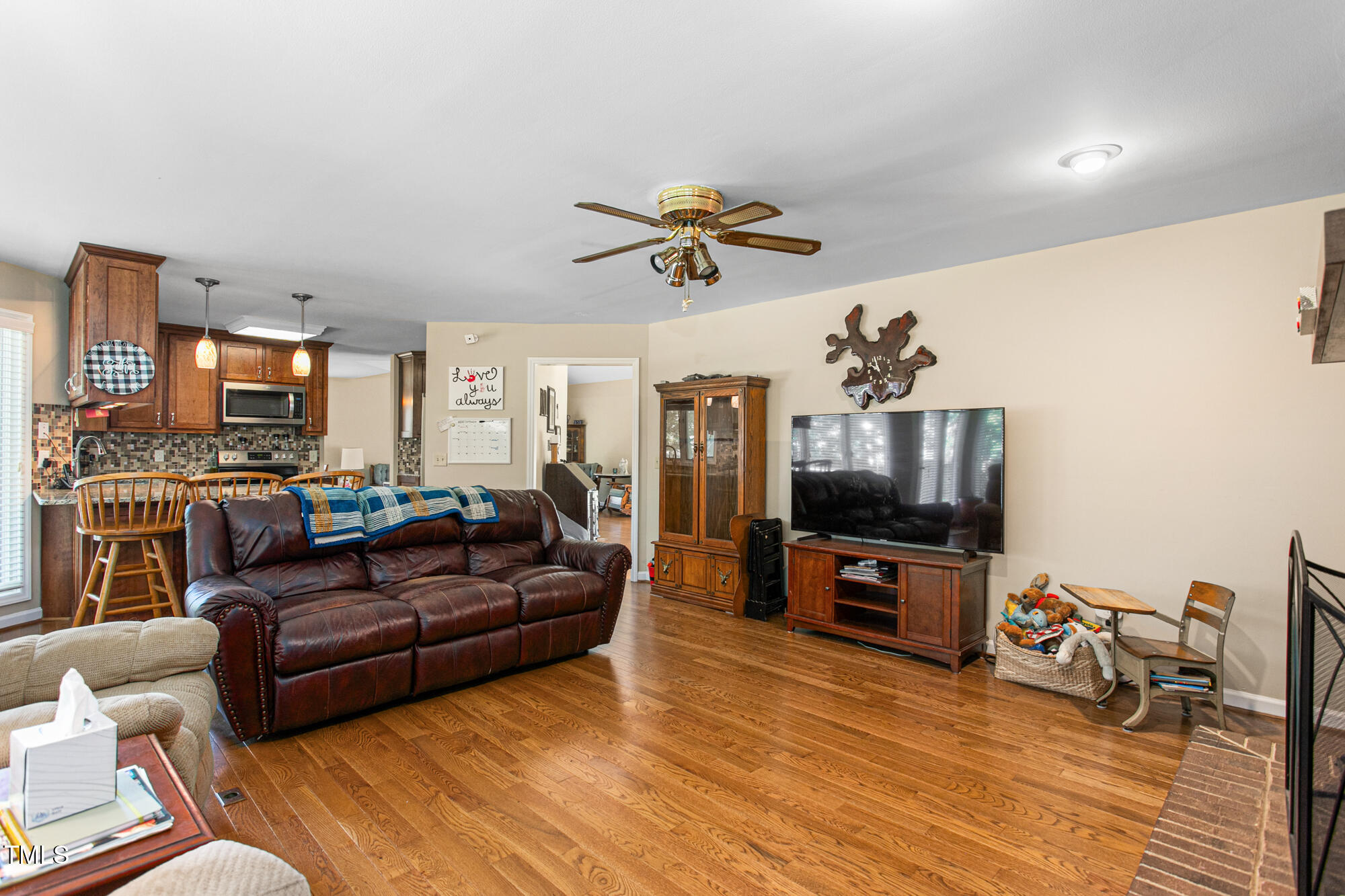 809 Brookview Drive Elon, NC 27244 - Photo 12 of 53 a living room with furniture a flat screen tv and kitchen view