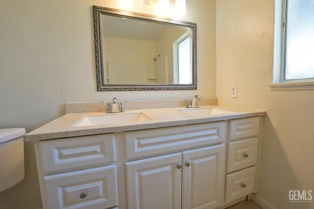 a bathroom with a granite countertop sink and a mirror