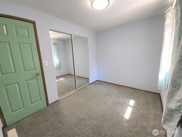 an empty room with windows and closet