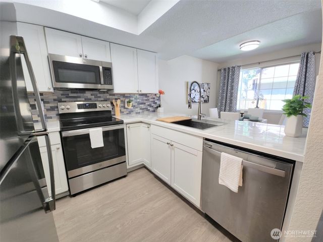 a kitchen with a sink stove and microwave