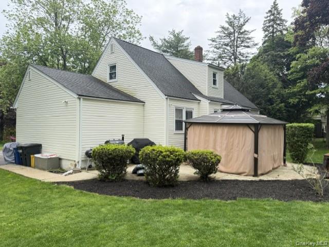 17 Mallory Road Spring Valley, NY 10977 - Photo 5 of 26 a backyard of a house with potted plants and a large tree