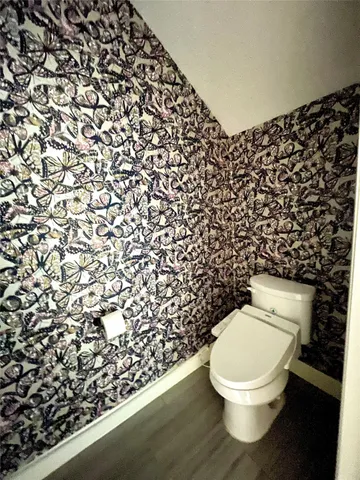 a bathroom with a toilet and a shower curtain