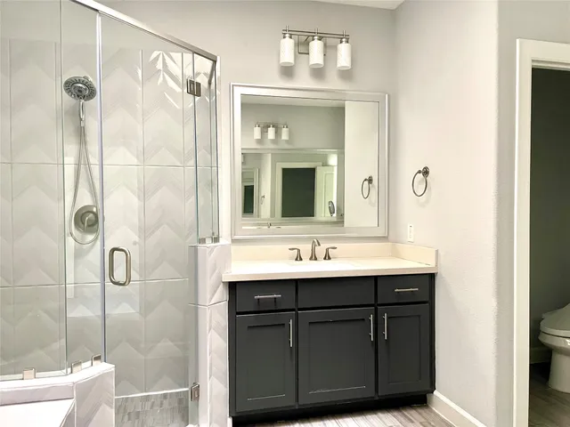 a bathroom with a double vanity sink mirror and shower