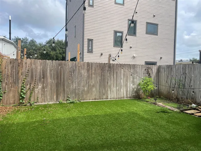 a view of backyard with potted plants and wooden fence