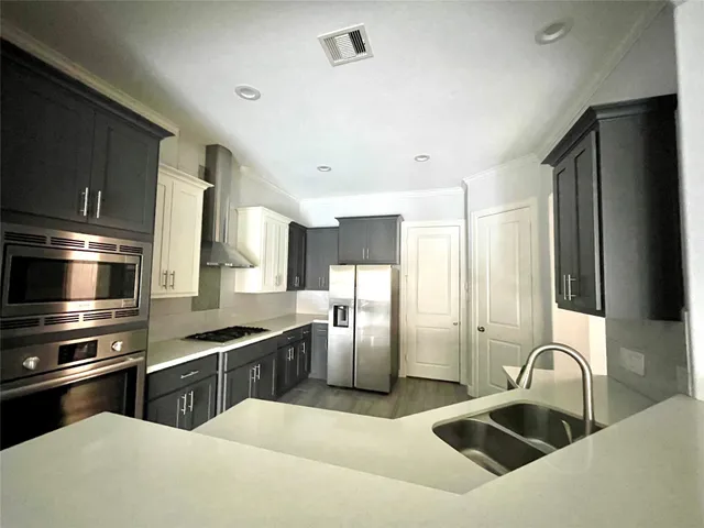 a kitchen with stainless steel appliances kitchen island granite countertop a refrigerator a sink a stove and trees