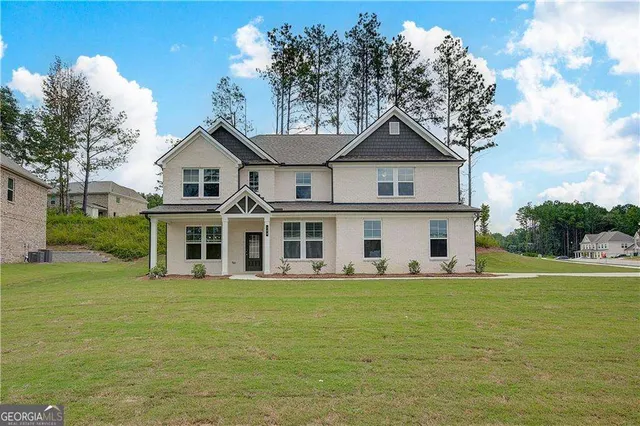 a view of a house with a big yard and large trees
