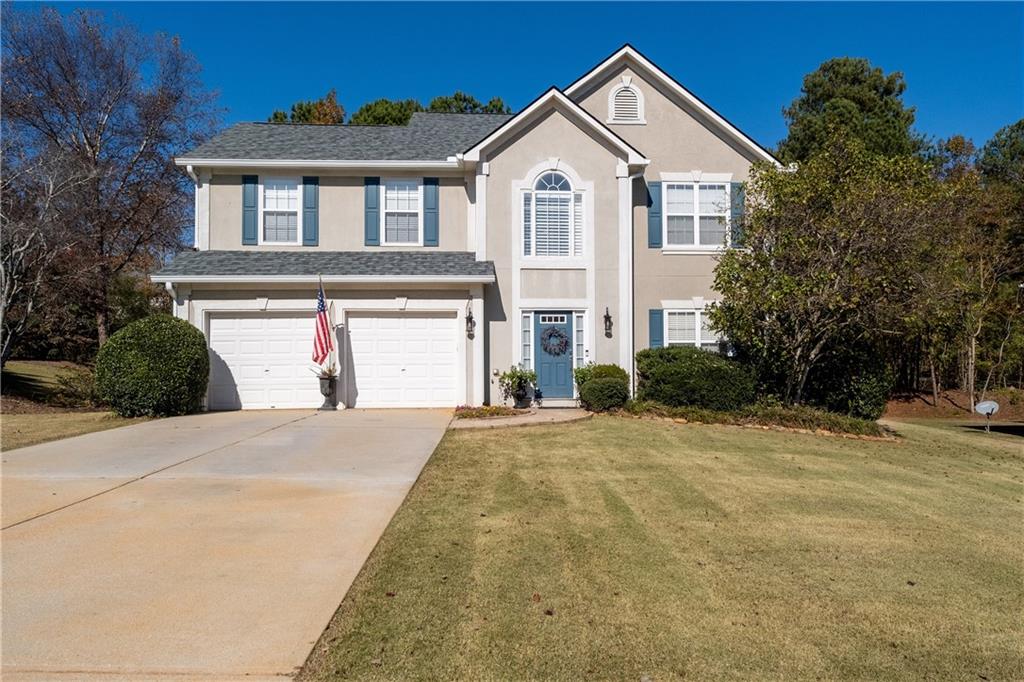 a front view of a house with a yard and garage