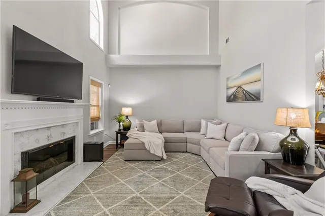 a living room with furniture a fireplace and a flat screen tv